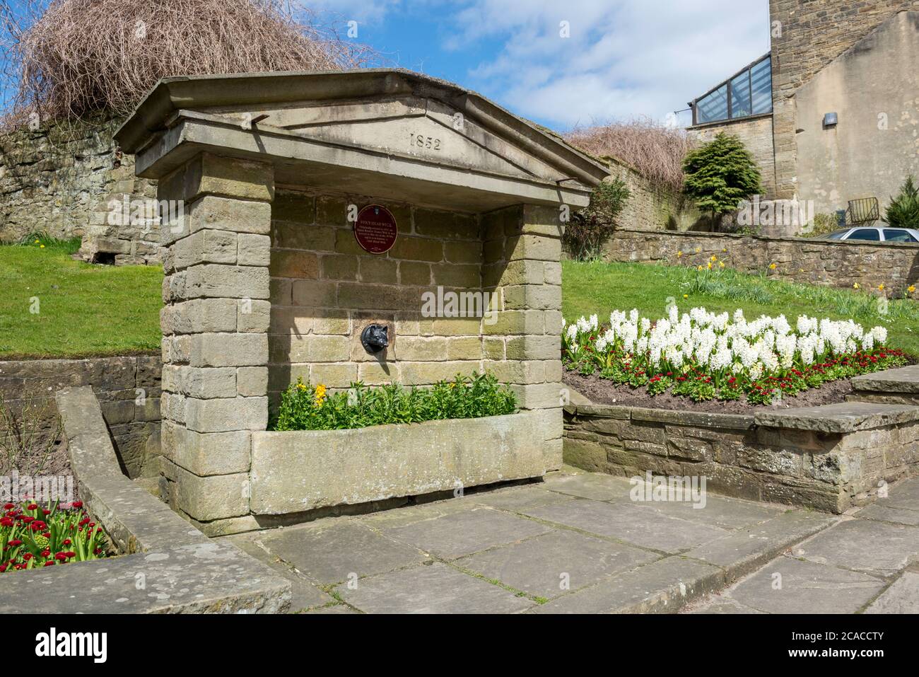 Fox's Head Fountain con atractivas muestras de flores en Pateley Bridge, North Yorkshire Foto de stock