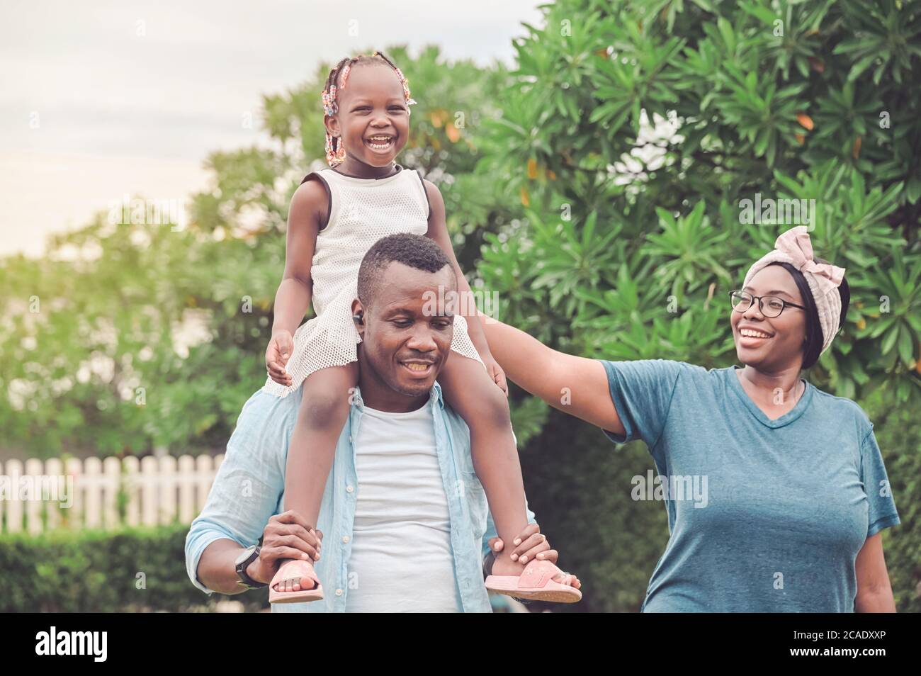 Felices familias afroamericanas caminando al aire libre lo pasaban muy bien juntas en el jardín de casa Foto de stock