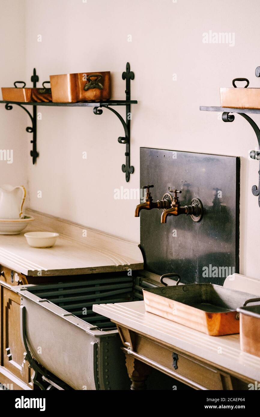 Antiguo fregadero de la cocina con dos grifos cerca de la encimera de  madera en la cocina con utensilios Fotografía de stock - Alamy
