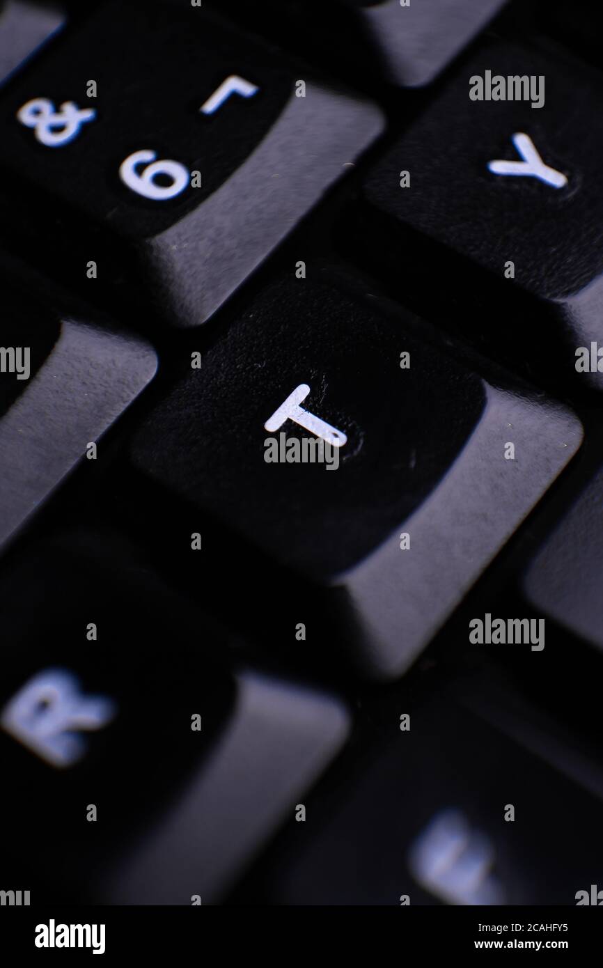 Vertical primer plano del teclado que señala la letra T Fotografía de stock  - Alamy