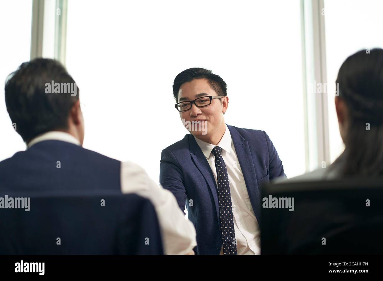 joven buscador de trabajo asiático que se sacude las manos con el gerente de recursos humanos antes de la entrevista de trabajo Foto de stock