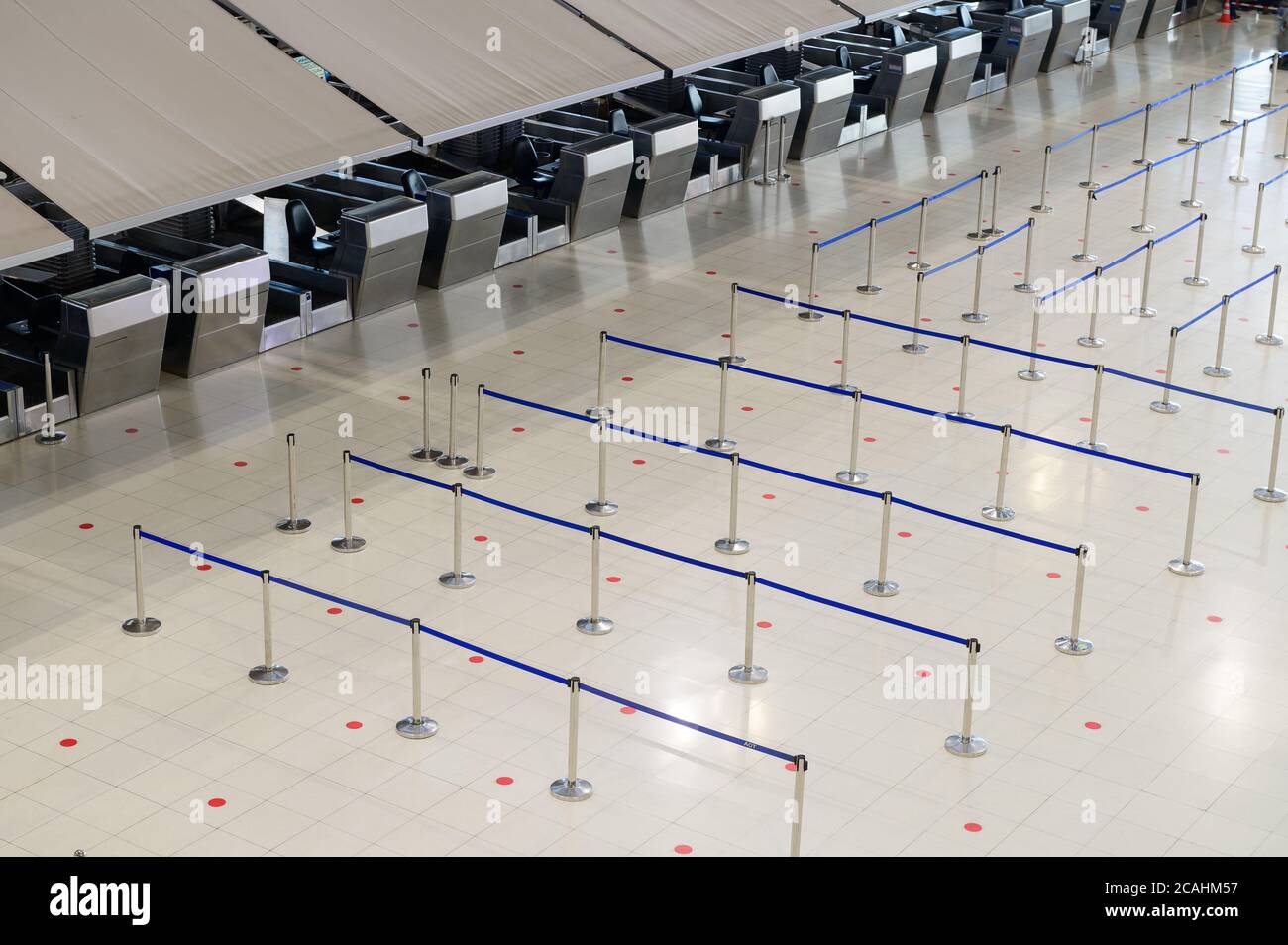 Mostrador de facturación del aeropuerto vacío con barreras de control de multitudes Foto de stock
