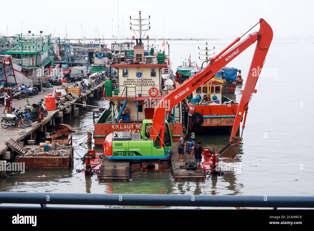 Yakarta, Indonesia - 21 de abril de 2019: Una excavadora operó para limpiar la basura en el puerto de Muara Angke, al norte de Yakarta. Foto de stock