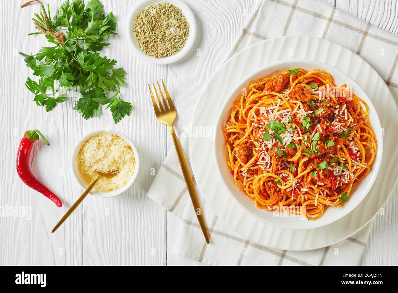espaguetis con ragout con tomates y salchichas de cerdo italiano molidas  rociadas con queso parmesano rallado y perejil picado en un tazón blanco,  ver Fotografía de stock - Alamy
