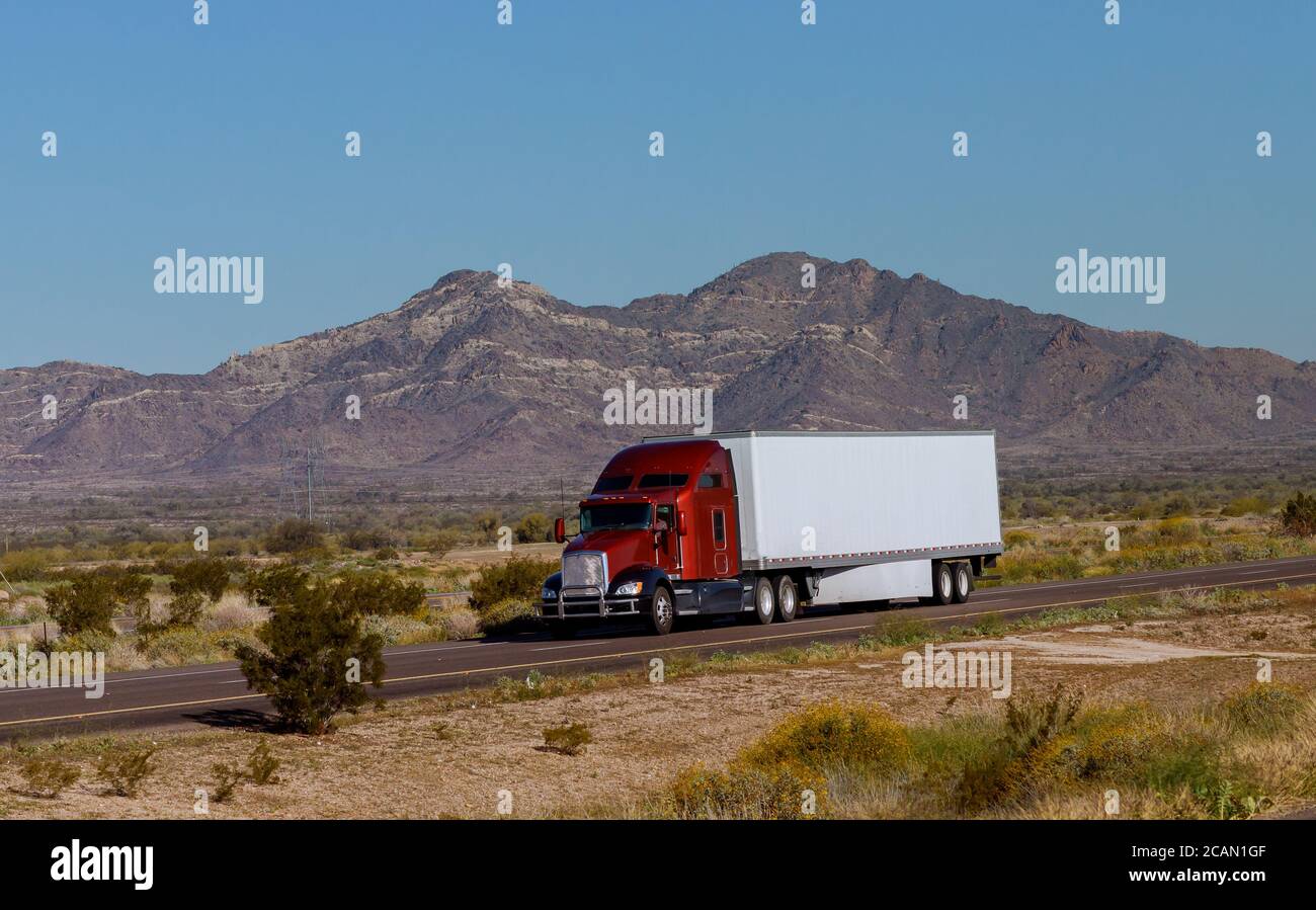 Classic Big RIG Heavy Duty Long haul diesel semi-camión con refrigerador semirremolque corriendo en la carretera a lo largo de las montañas En EE.UU Foto de stock