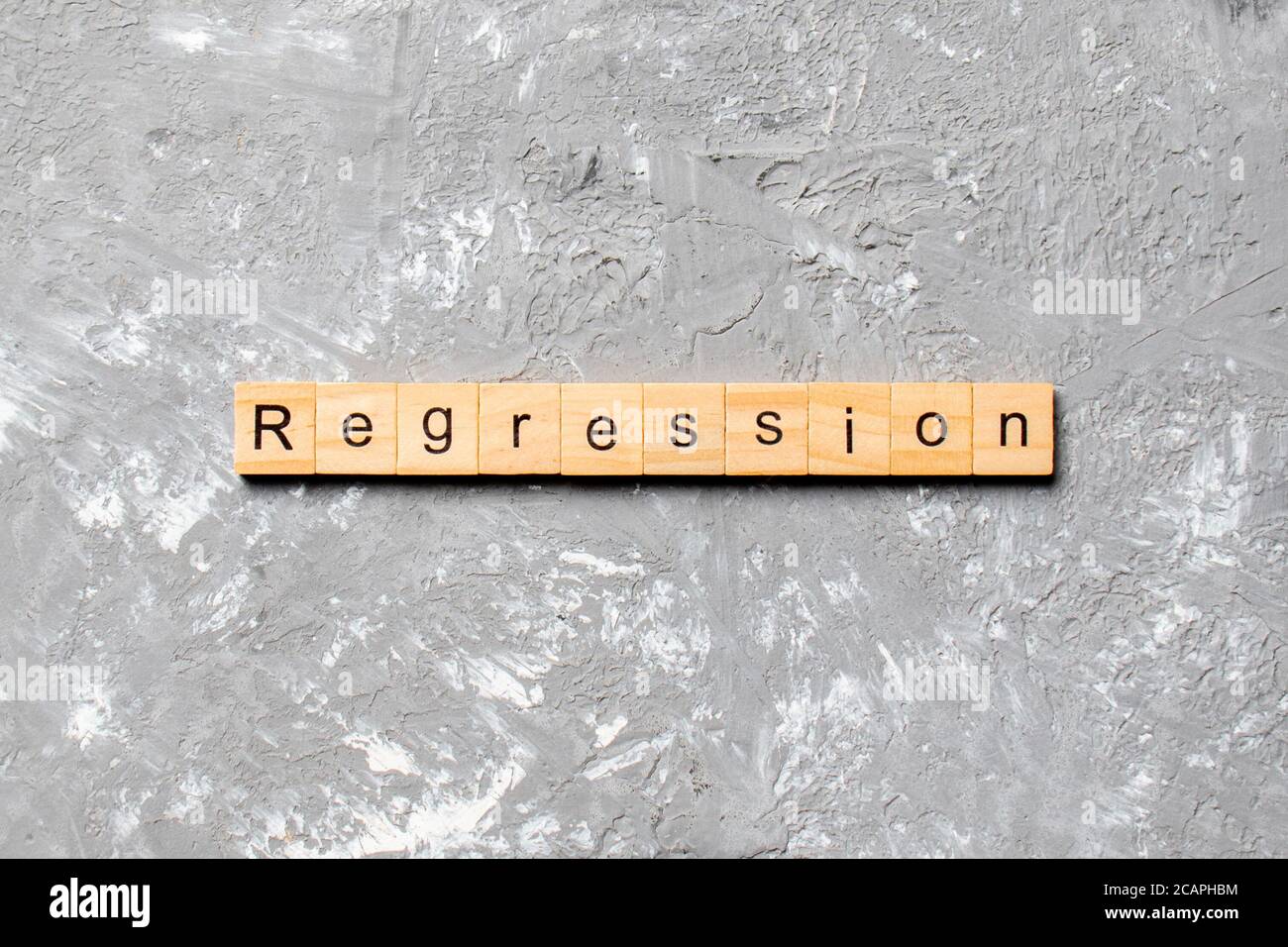 palabra de regresión escrita en bloque de madera. texto de regresión en tabla de cemento para su diseño, concepto. Foto de stock