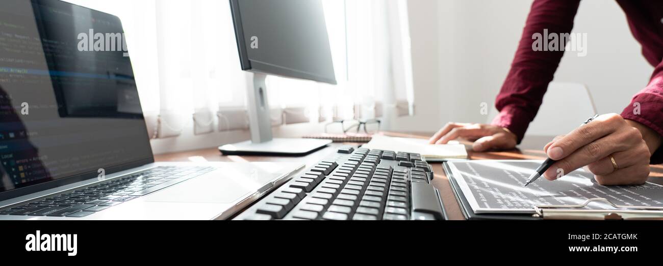 Desarrollador de software o programador datos de trabajo depuración algoritmo binario de mejora en un pc de escritorio en un software desarrollar la oficina de la empresa Foto de stock