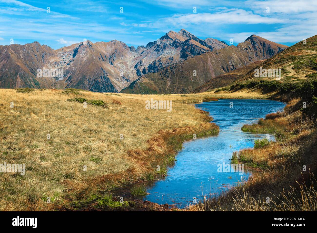 Pintoresco paisaje de montaña con pequeño lago y montañas en el fondo, montañas Fagaras, Cárpatos, Rumania, Europa Foto de stock