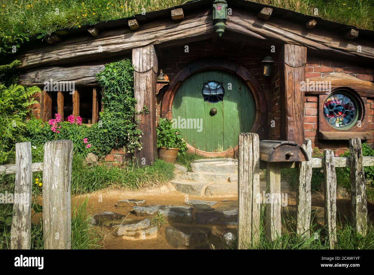 Puerta verde de una casa Hobbit en el escenario de Hobbiton. Foto de stock
