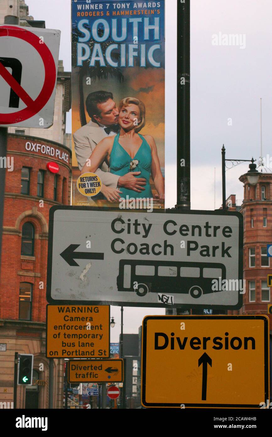 Señales y anuncios, esquina de Portland Street y Oxford Road, Manchester Central, Inglaterra, Reino Unido Foto de stock