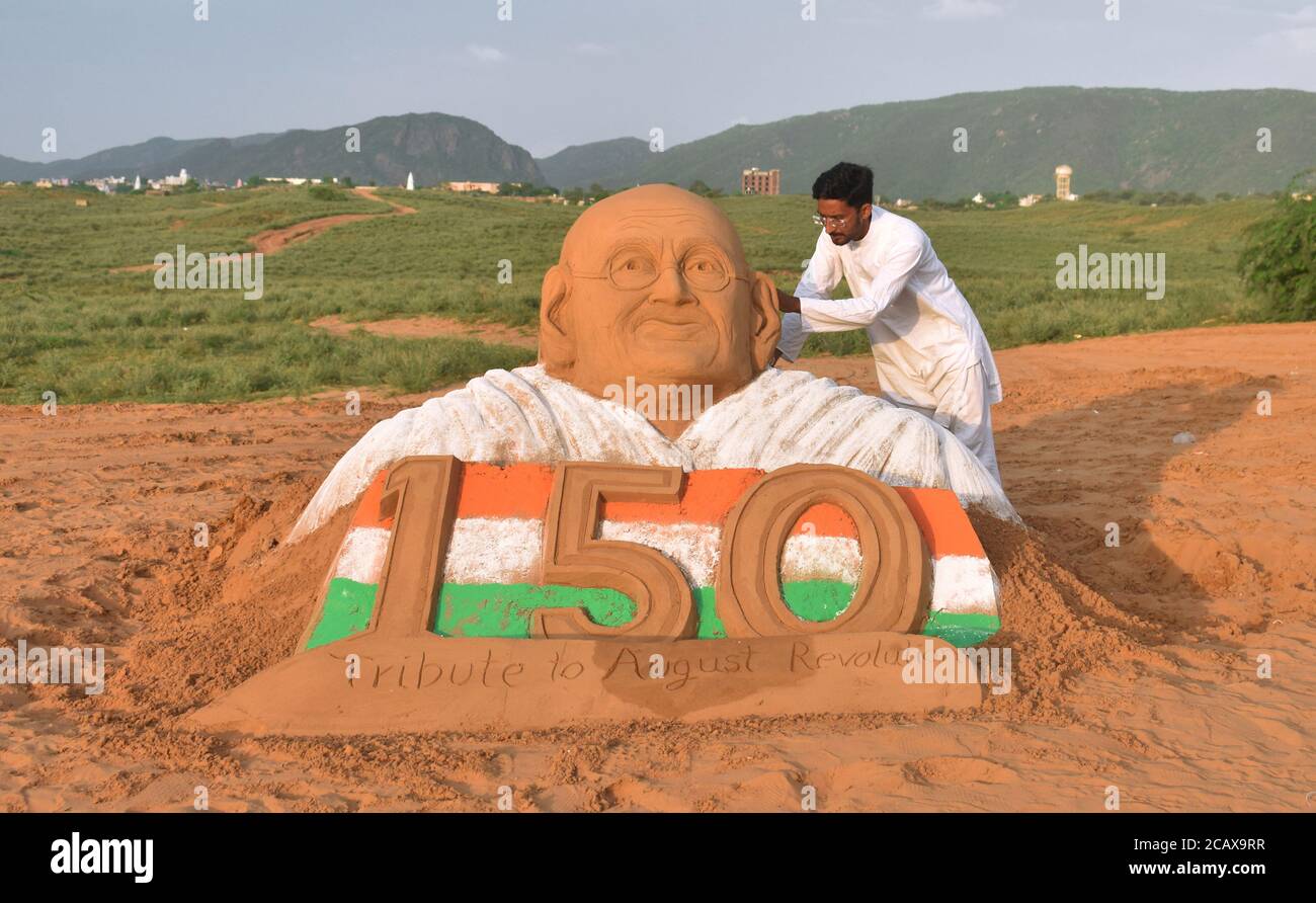 Pushkar, Rajasthan, India, 9 de agosto de 2020: El artista de arena Ajay Rawat da un toque final a una escultura de Mahatma Gandhi para marcar el August Kranti Diwas (día de la Revolución), en Pushkar. El 9 de agosto de 1942, Gandhi pidió un movimiento de masas para exigir la retirada británica de la India. Crédito: Sumit Saraswat/Alamy Live News Foto de stock