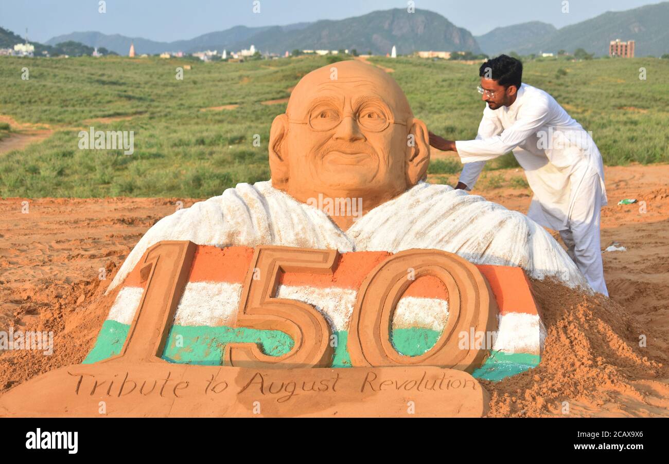 Pushkar, Rajasthan, India, 9 de agosto de 2020: El artista de arena Ajay Rawat da un toque final a una escultura de Mahatma Gandhi para marcar el August Kranti Diwas (día de la Revolución), en Pushkar. El 9 de agosto de 1942, Gandhi pidió un movimiento de masas para exigir la retirada británica de la India. Crédito: Sumit Saraswat/Alamy Live News Foto de stock