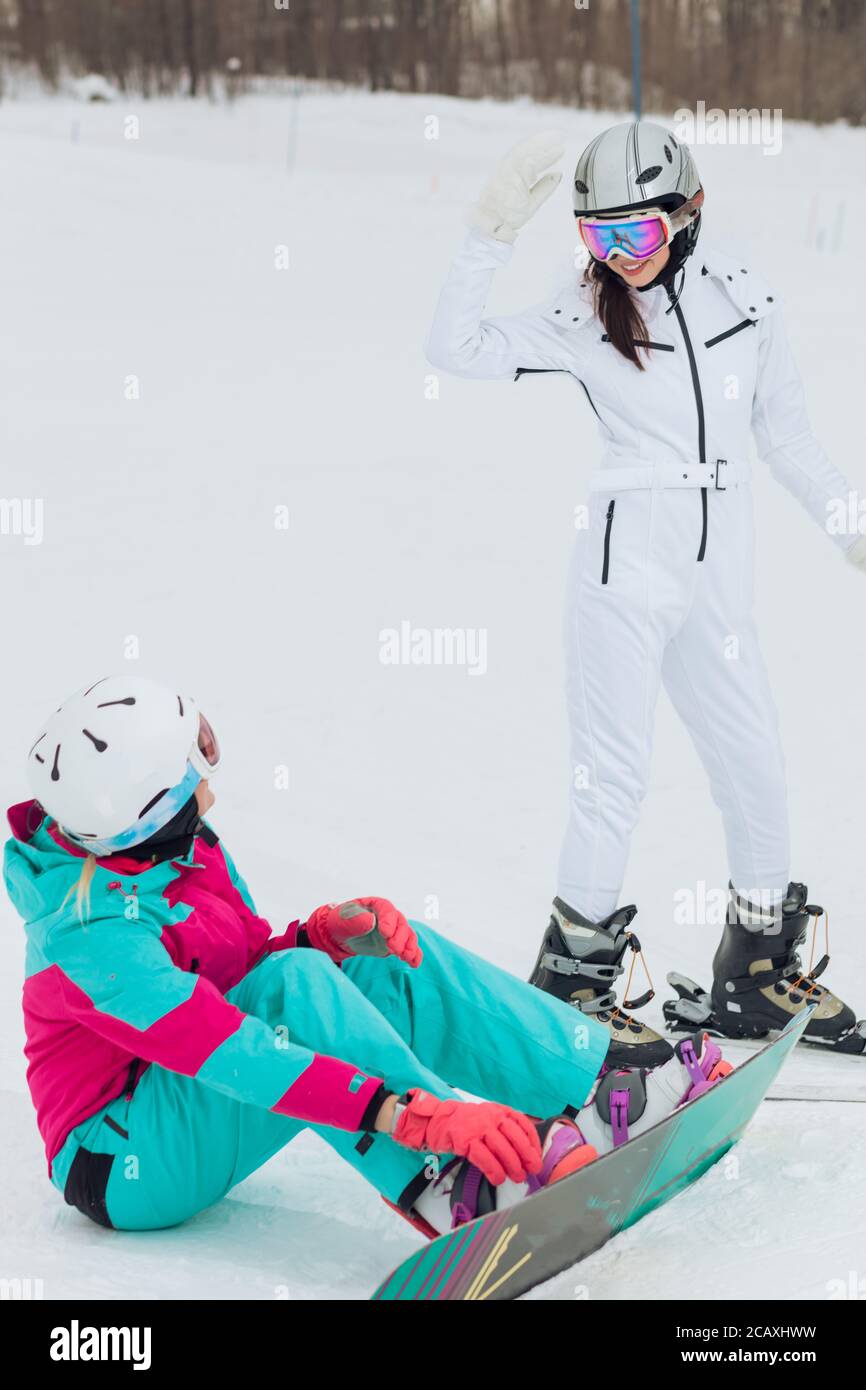 smiling agradable sportwomen tener un descanso después del esquí y el  snowboard, mujeres haciendo amigos en las vacaciones de invierno Fotografía  de stock - Alamy