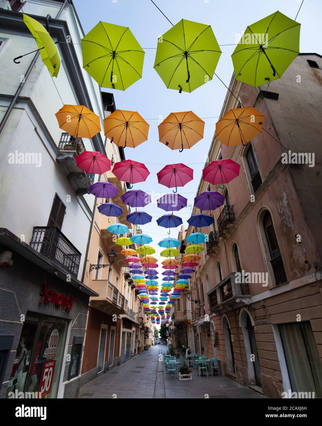 Glesias, Italia: Coloridos paraguas colgando sobre una calle en la ciudad  vieja de Iglesias en un día soleado Fotografía de stock - Alamy