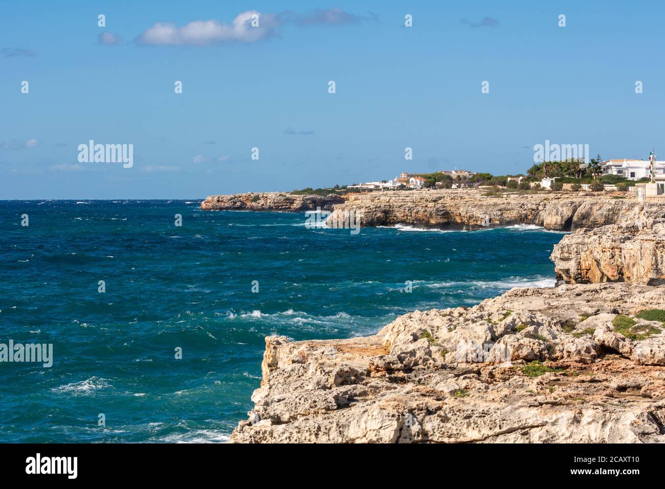 Mar azul y costa rocosa del oeste de Menorca, puerto de Ciutadella. Menorca, España Foto de stock