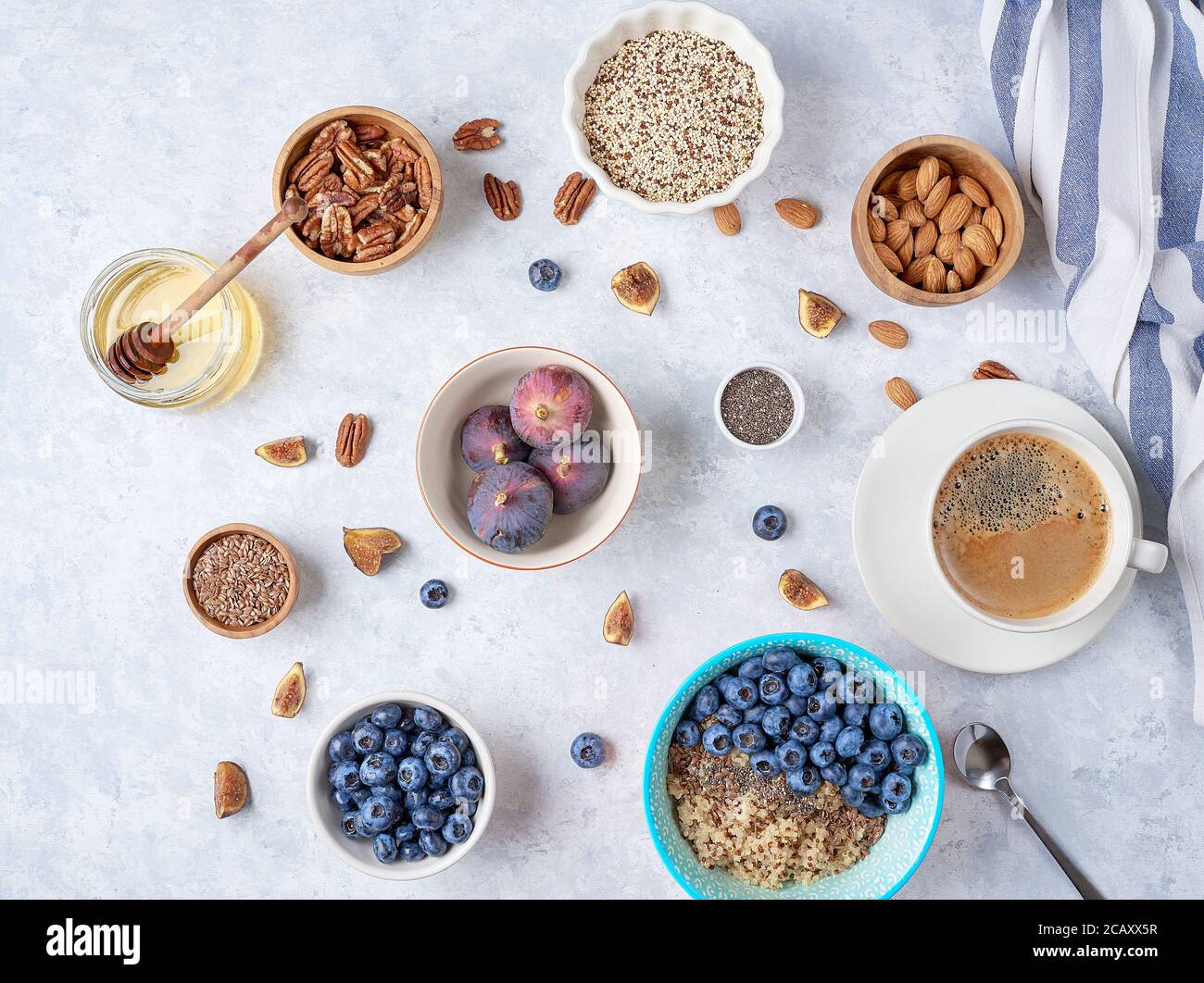Desayuno saludable de fuentes alimenticias, quinua, miel, nueces, higos, café. Vista superior Foto de stock
