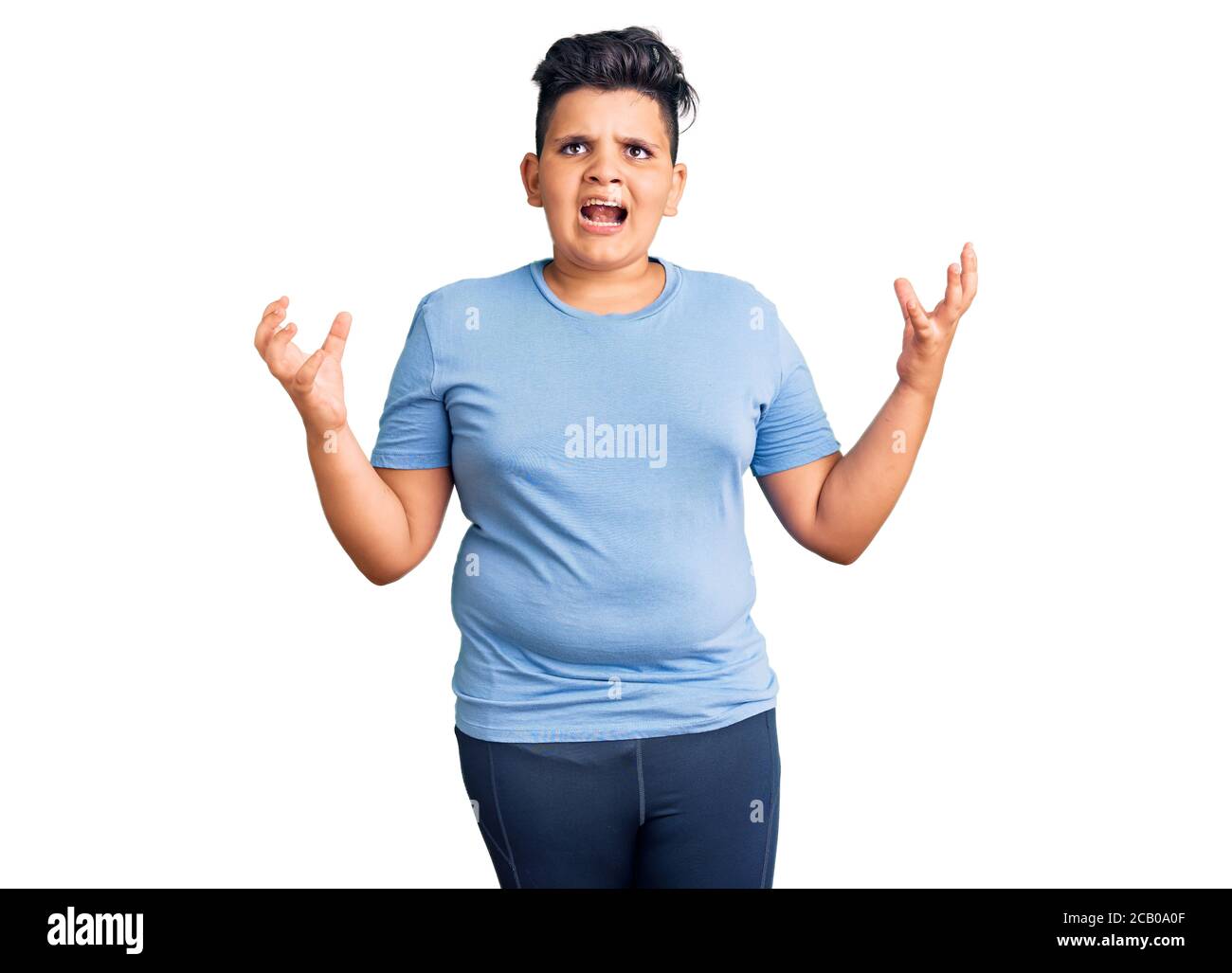 Niño pequeño con ropa deportiva de entrenamiento loco y loco gritando y  gritando con expresión agresiva y los brazos levantados. Concepto de  frustración Fotografía de stock - Alamy