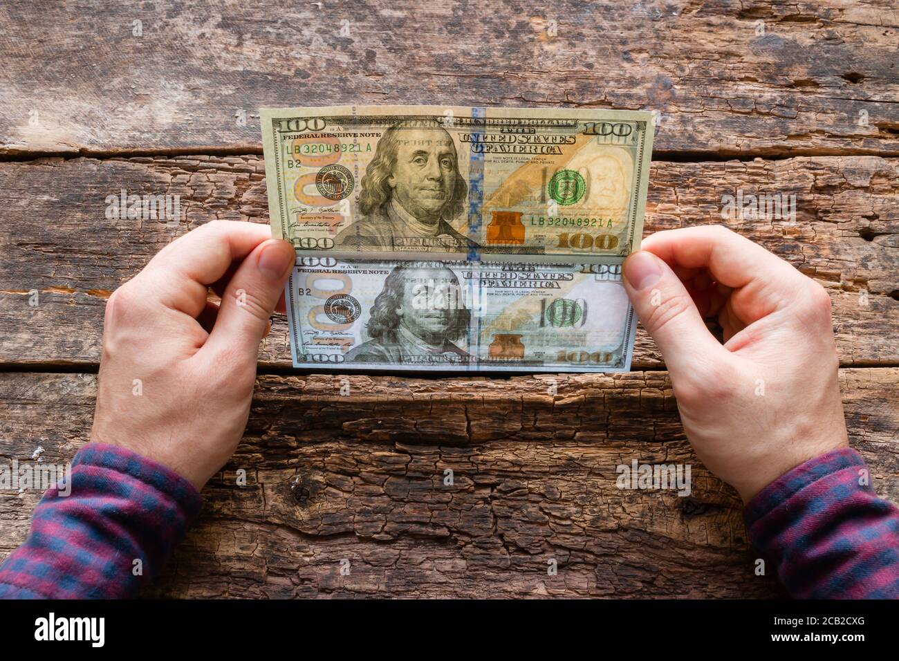 el hombre muestra la diferencia entre un billete auténtico y un billete