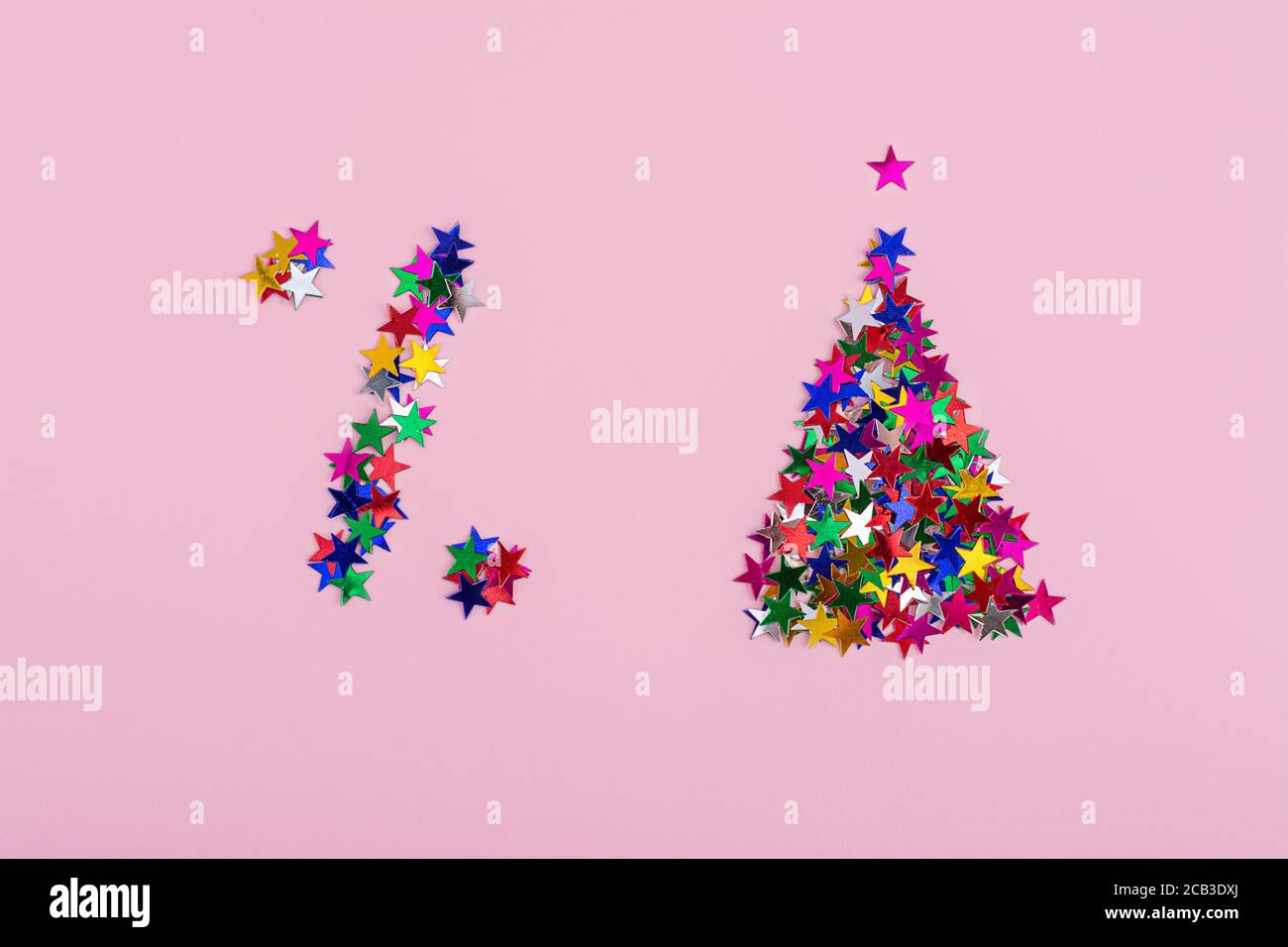 Símbolo de descuento y un árbol de Navidad de estrellas multicolor sobre un fondo rosa. Un signo de porcentaje, ventas de Navidad Foto de stock