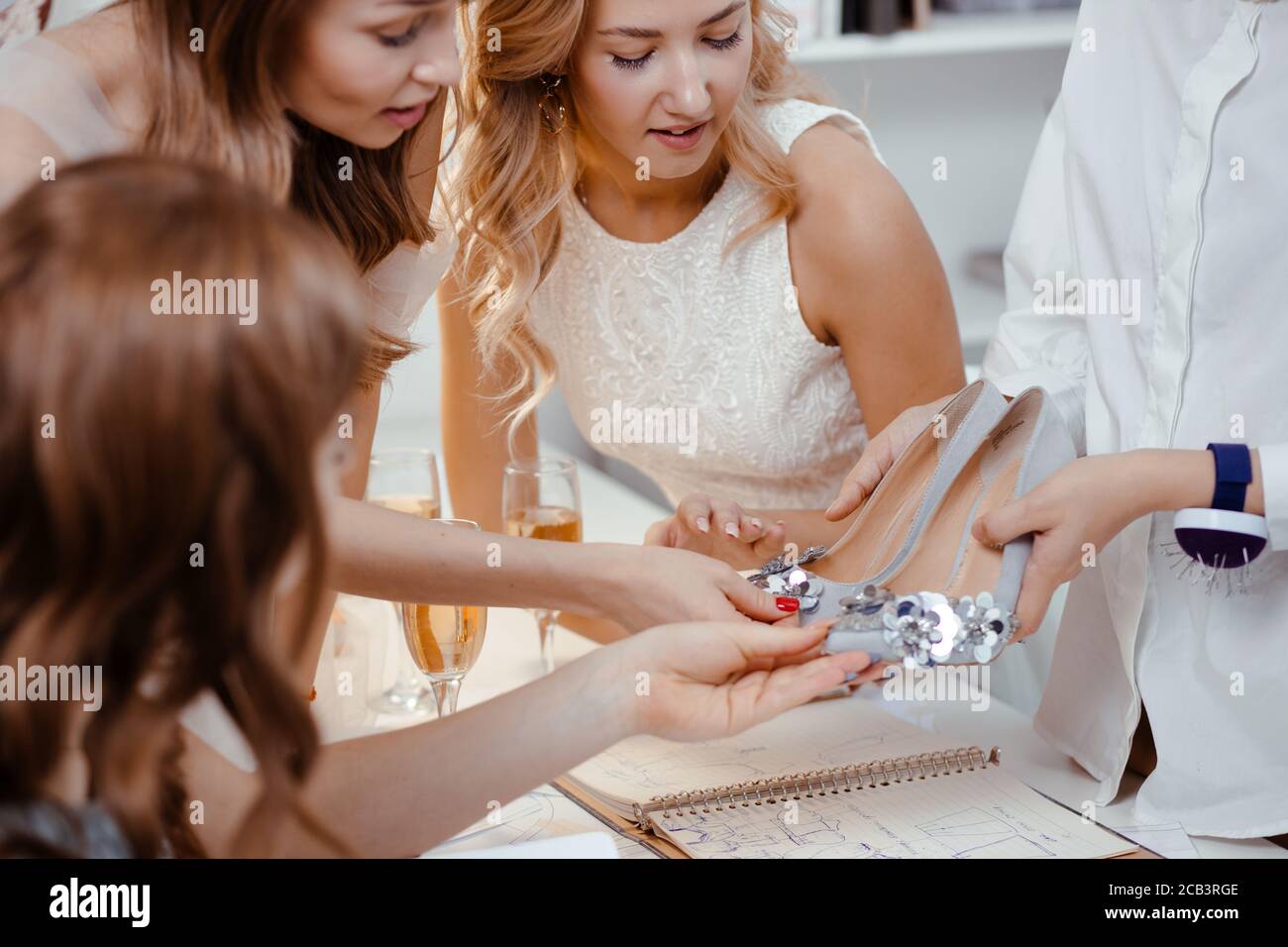 mujer joven mostrando zapatos de diseño a las damas en vestidos,  presentación de nuevos zapatos en el salón. Diseño, celebración, ropa,  calzado, concepto de calzado Fotografía de stock - Alamy