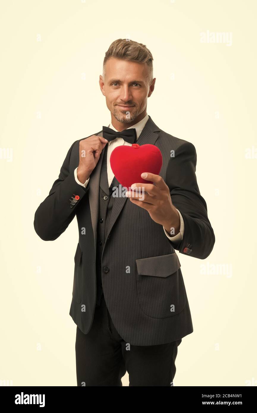 Celebración del amor. Tuxedo hombre rojo san Valentín corazón. Listo para  la fecha romántica. Ocasión especial. Elegante hombre confiado aislado en  blanco. Traje de hombre de negocios. Símbolo de amor en día