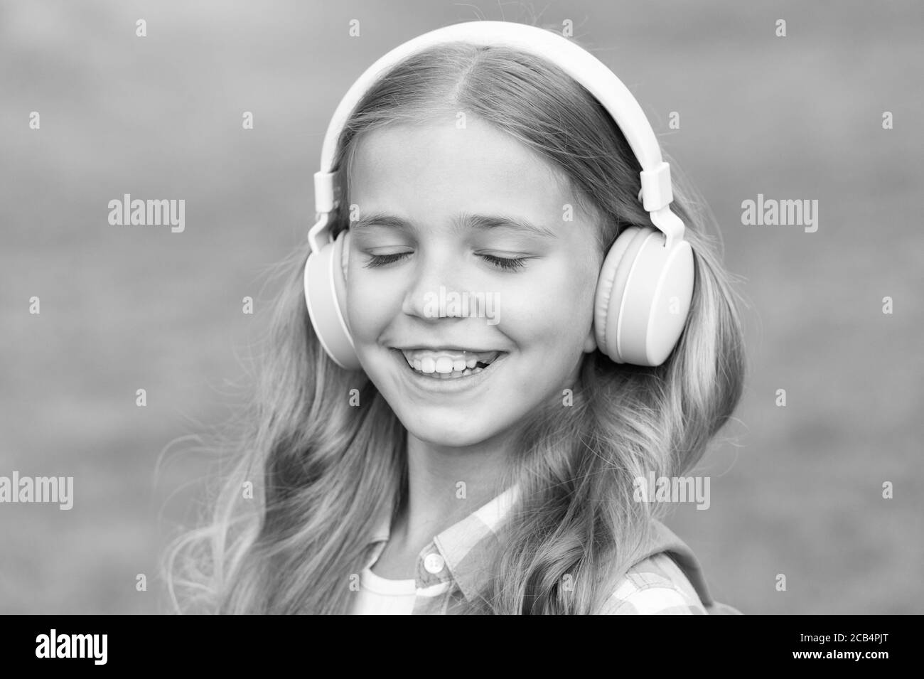 Escuche música mientras camina. Auriculares para chicas escuchando música.  Podcast educativo. Niña disfrutar de la música. Lo ha llegado muy bien. Los  auriculares para niños escuchan música. Concepto de libro de audio.