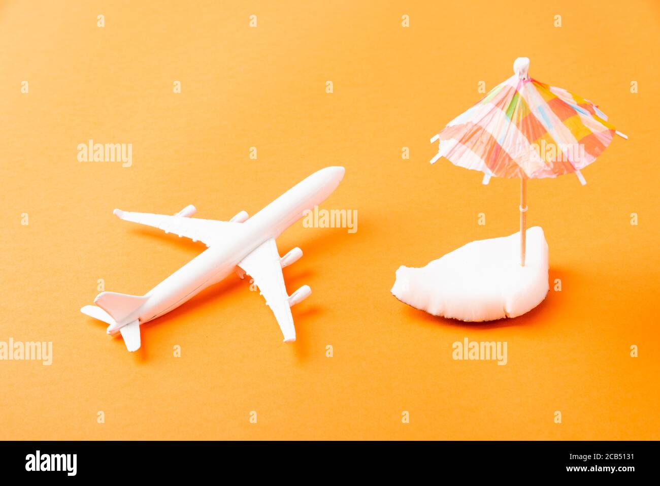 Feliz concepto de día de cocos, frescos trozos de coco, avión, modelo de  avión y paraguas, estudio disparo aislado sobre fondo naranja, playa trop  Fotografía de stock - Alamy