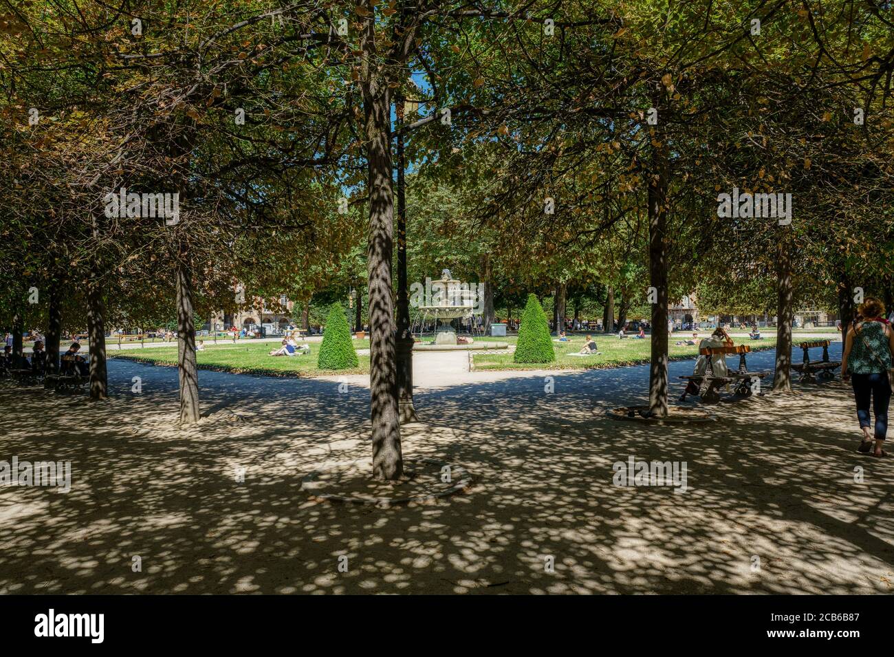 Gente que se relaja en el césped verde de la famosa Place des Vosges - París, Francia Foto de stock