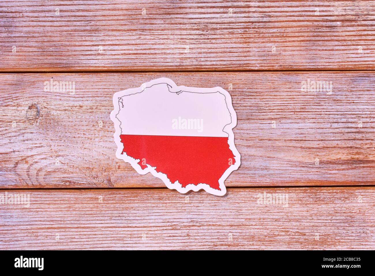 Mapa de fronteras de Polonia. Forma y bandera nacional sobre fondo blanco de madera. Espacio de copia para diseño Foto de stock