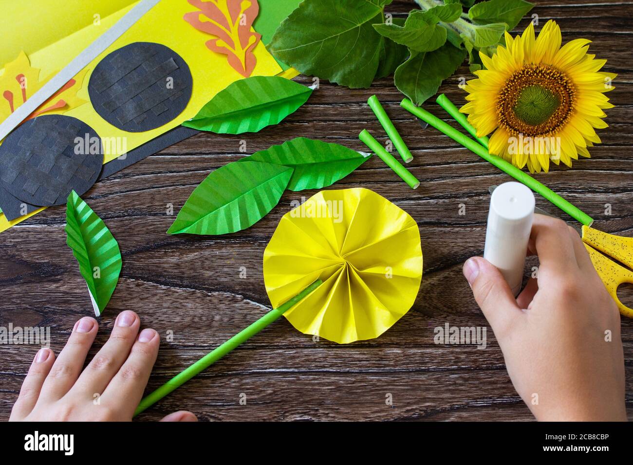 Instrucciones, paso 10. Regalo de un papel, flor de girasol en una mesa de  madera. Proyecto de arte infantil, artesanal, artesanía para niños  Fotografía de stock - Alamy