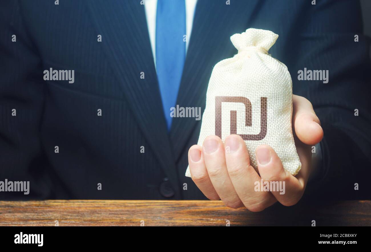Un hombre de negocios tiene en su mano una bolsa de dinero de shekel israelí. Estimular la recuperación económica. Proporcionar a las empresas préstamos preferenciales y duri de apoyo Foto de stock