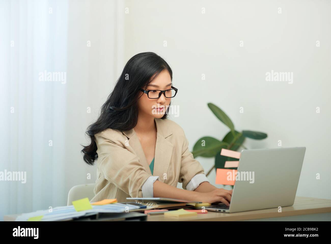 Head shot agradable mujer joven feliz trabajando en la computadora en casa. Foto de stock