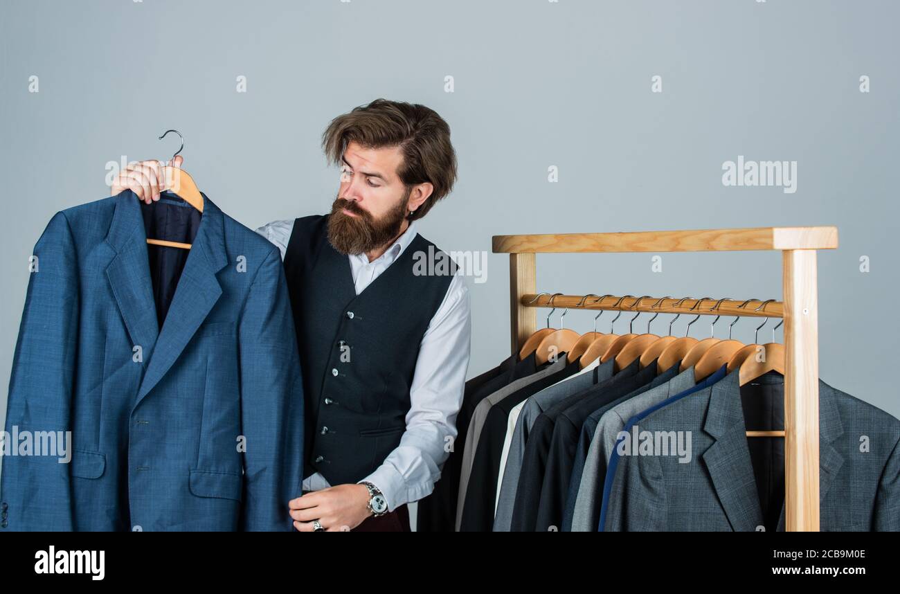 Considerar comerciante pavimento Hombre barbudo colección ropa vintage mostrando traje formal, segunda mano  tienda concepto Fotografía de stock - Alamy