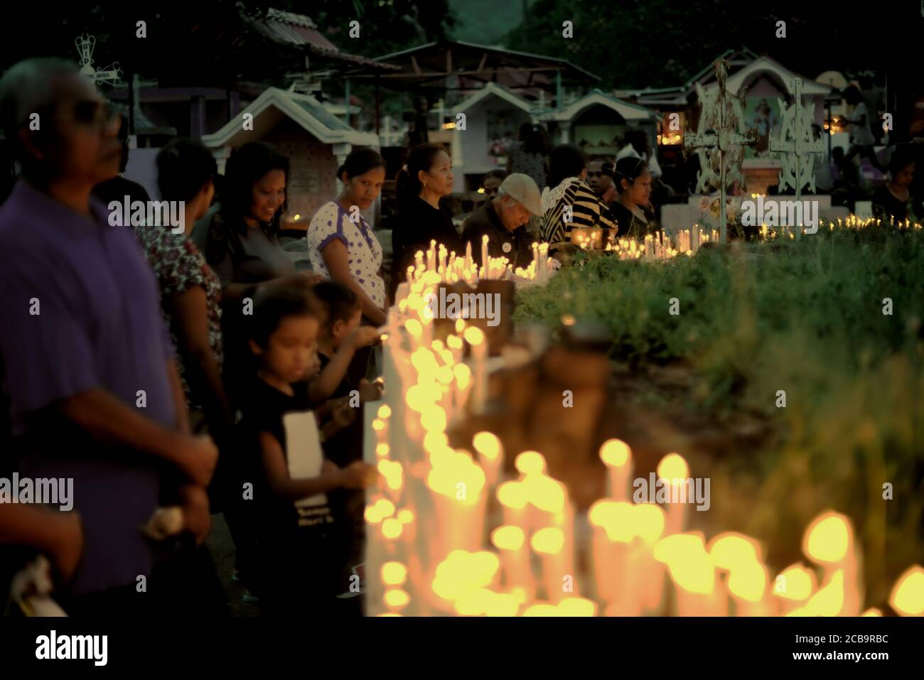 Larantuka, Indonesia. 3 de abril de 2015. Devotos católicos y peregrinos encendiendo velas y oren en el complejo cementerio de la Catedral de Larantuka durante la conmemoración del Viernes Santo en Larantuka, Isla Flores, Indonesia. Foto de stock
