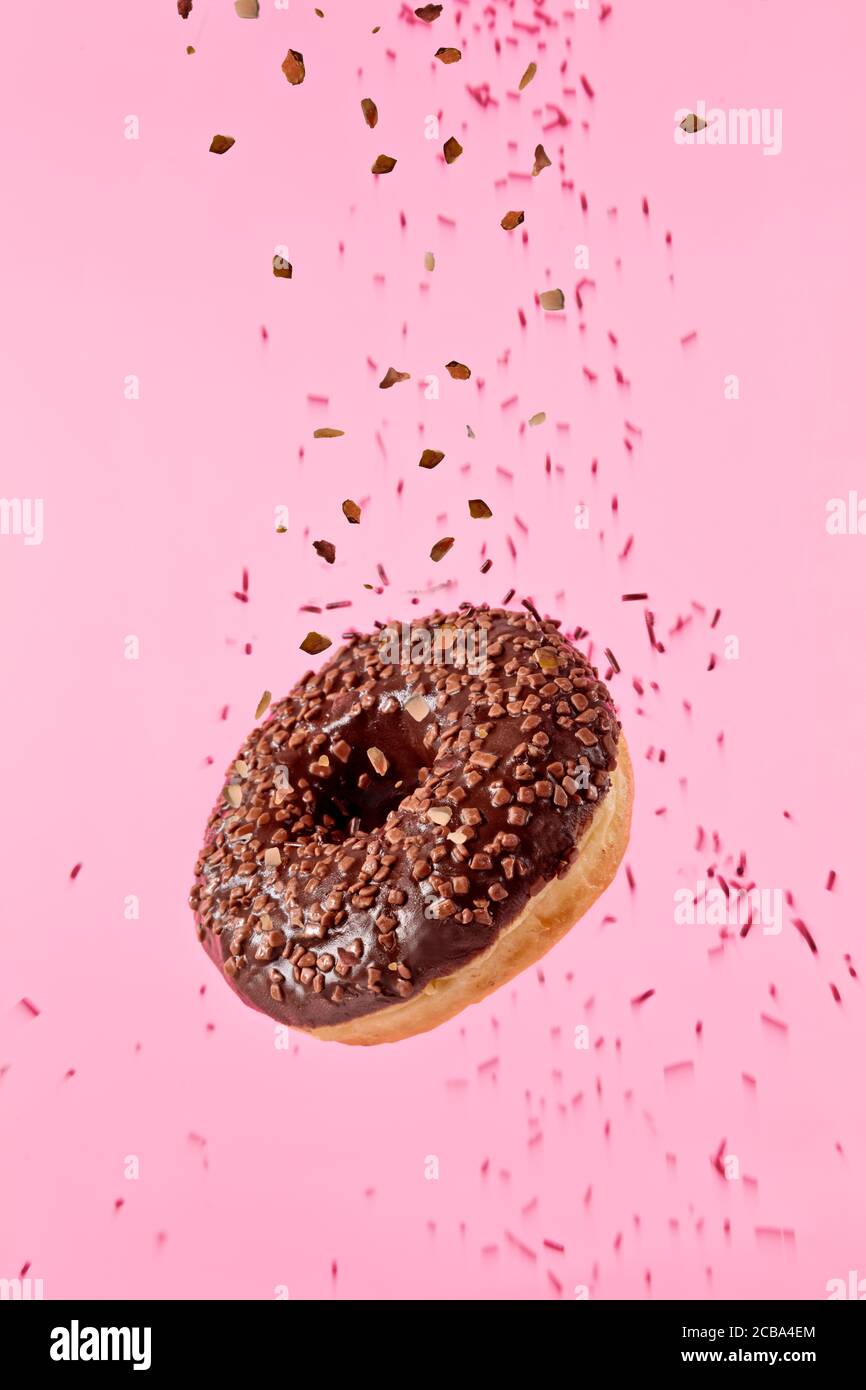 Flying chocolate dulce donut aislado sobre fondo de color rosa. Concepto de  alimentos de baja gravedad en efecto congelar el movimiento. Imagen de alta  resolución Fotografía de stock - Alamy