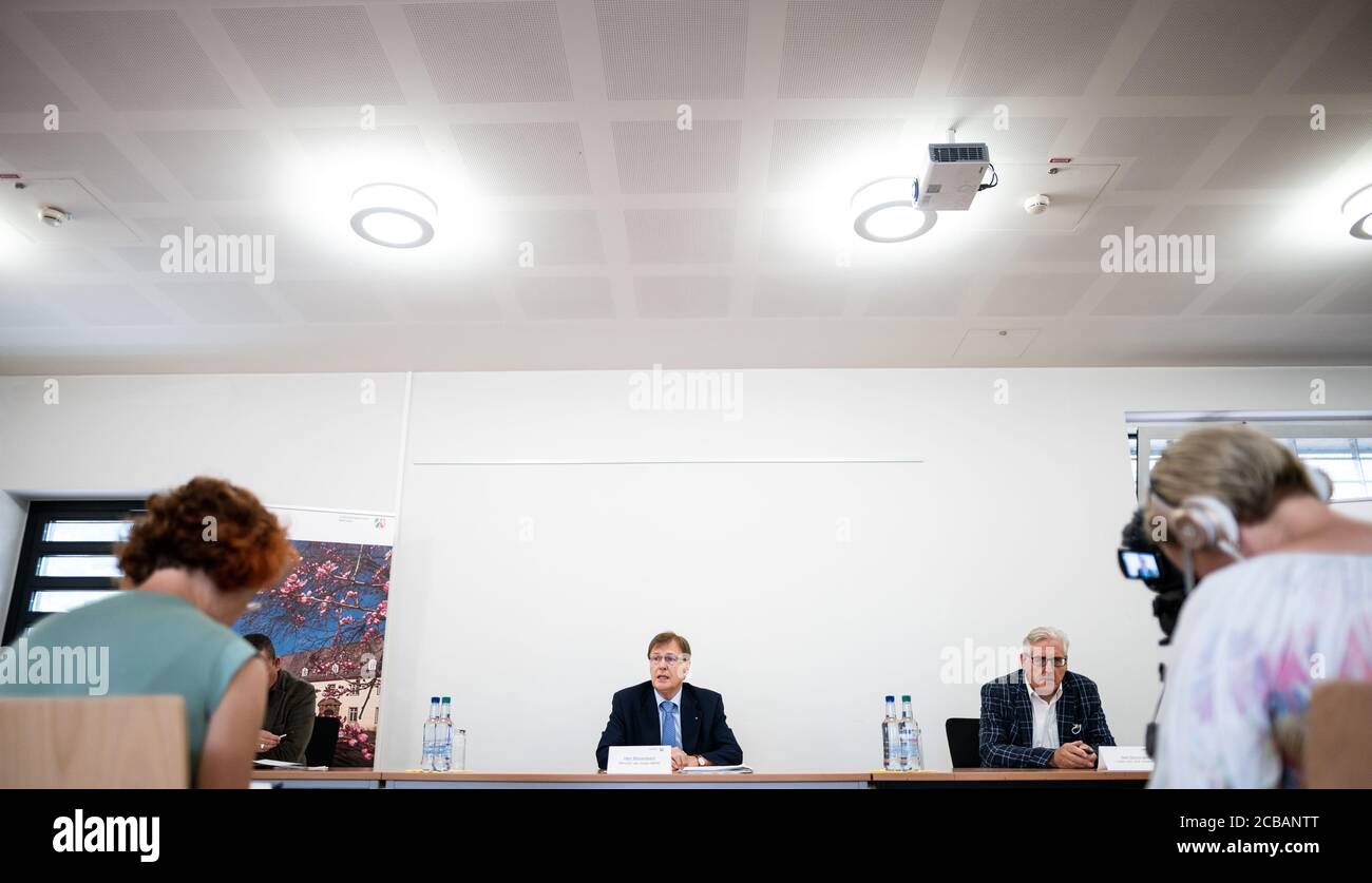 Attendorn, Alemania. 12 de agosto de 2020. Peter Biesenbach (CDU, centro), Ministro de Justicia de Renania del Norte-Westfalia, y Ulf Borrmann (atrás, derecha), jefe de la prisión de Attendorn, hablan en una conferencia de prensa sobre el proyecto piloto de telemedicina en curso en las prisiones. Gracias a la tecnología digital, los presos pueden acceder a la atención médica fuera del horario de oficina y dentro de las paredes de la prisión las 24 horas del día con transmisiones en vivo. Siete de las 36 prisiones de NRW participan en el proyecto piloto: Aachen, Attendorn, Bielefeld-Senne, Herford, Werl, Hamm y Duisburg-Hamborn. Crédito: Fabian Strauch/dpa/Alamy Live News Foto de stock