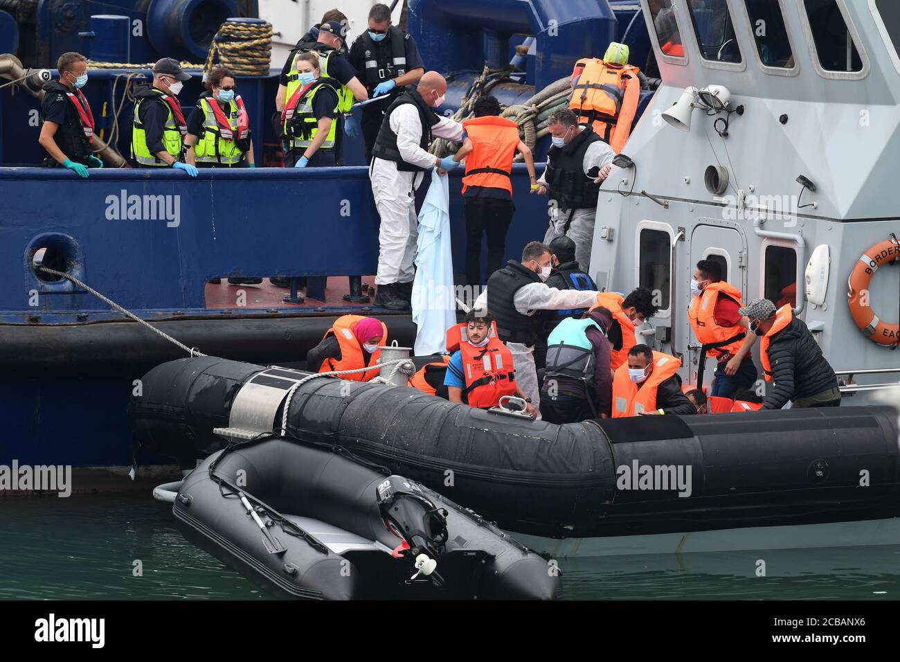 Un grupo de personas que se cree que son migrantes, desembarcan cuando son traídas a Dover, Kent, por oficiales de la Fuerza Fronteriza, después de un número de pequeños incidentes de barcos en el Canal de la Mancha a principios de hoy. Foto de stock
