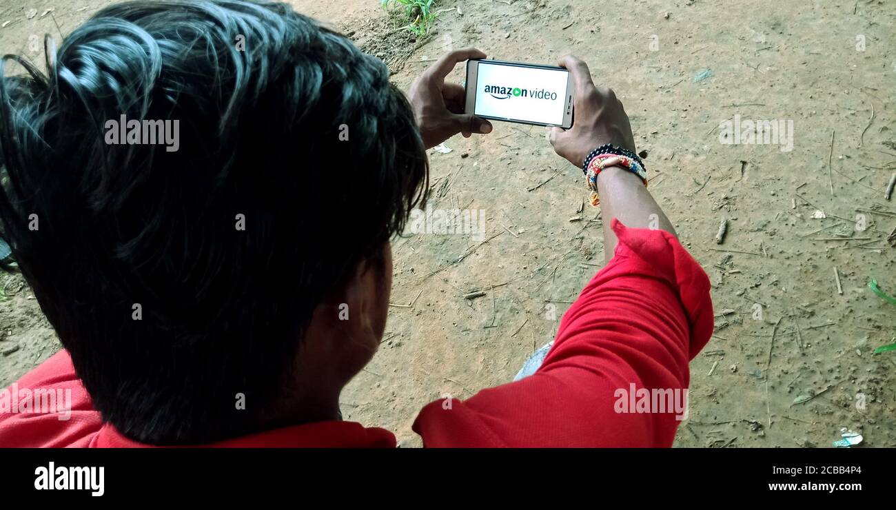 DISTRITO KATNI, INDIA - 18 DE SEPTIEMBRE de 2019: Amazon Prime Video logo mostrado en la pantalla de teléfono inteligente por el hombre de la aldea india mano sosteniendo el concepto móvil. Foto de stock