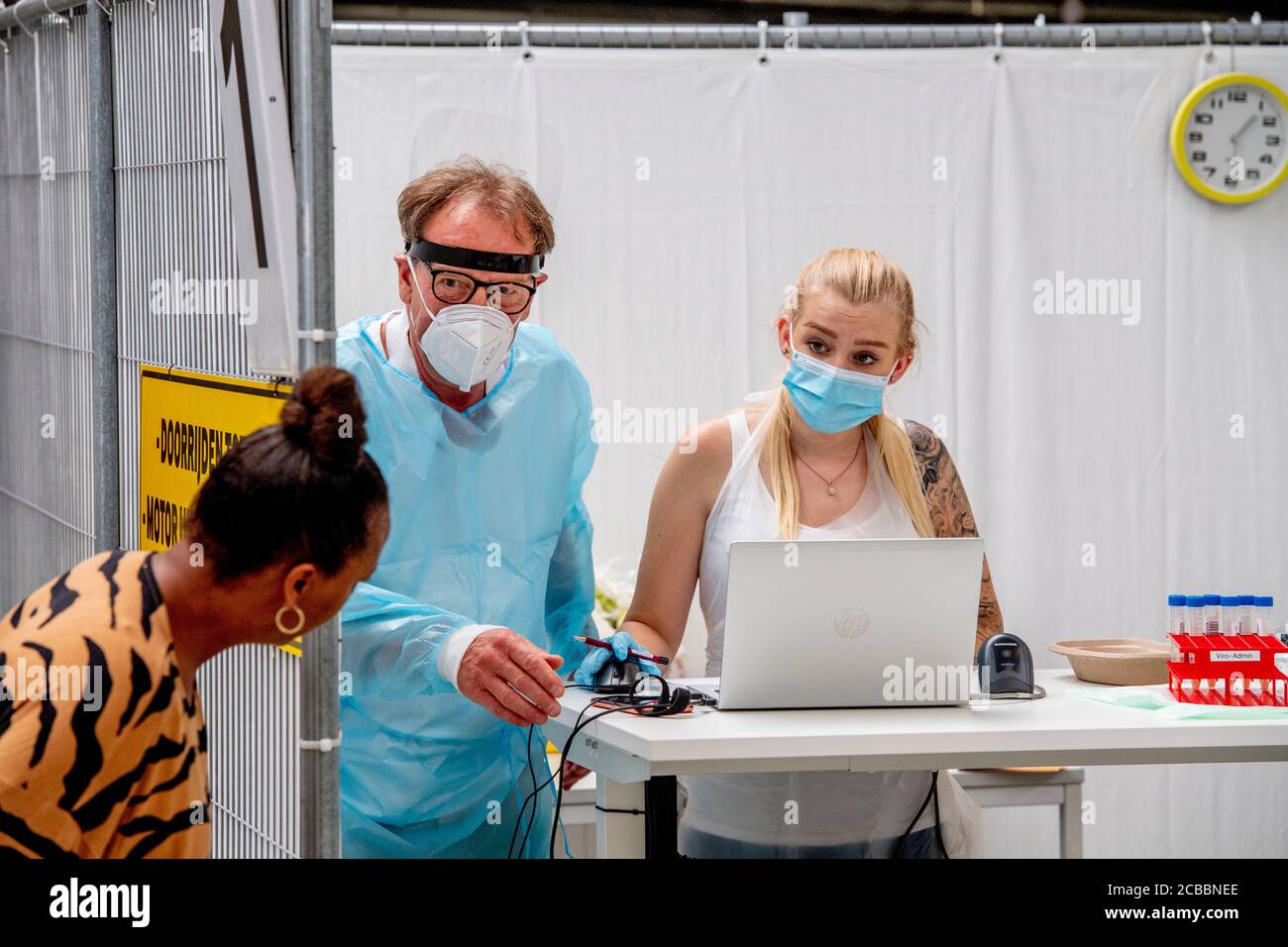 Una mujer consulta a los trabajadores de la salud durante las pruebas de conducción.otro lugar de prueba de conducción de coronavirus fue puesto en Schiedam donde se hacen pruebas a personas que tienen quejas o preocupaciones en relación con el coronavirus. Casi 1000 personas pueden ser sometidas a pruebas en el centro de pruebas de conducción de schiedam con cita previa al día tras el aumento mundial de las infecciones por coronavirus. Foto de stock