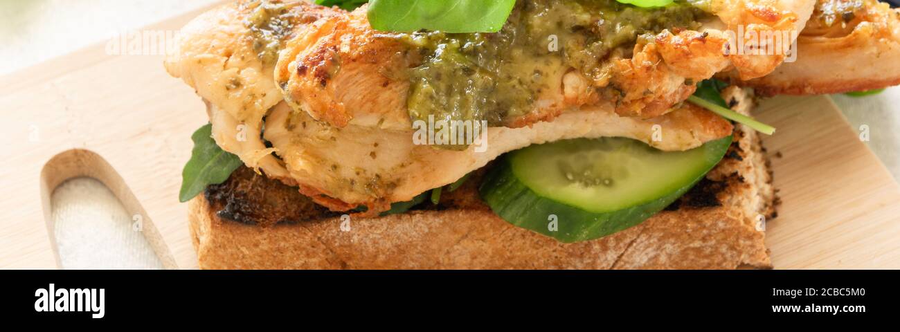 Sándwich listo para comer con carne de pollo a la parrilla y albahaca pesto Foto de stock