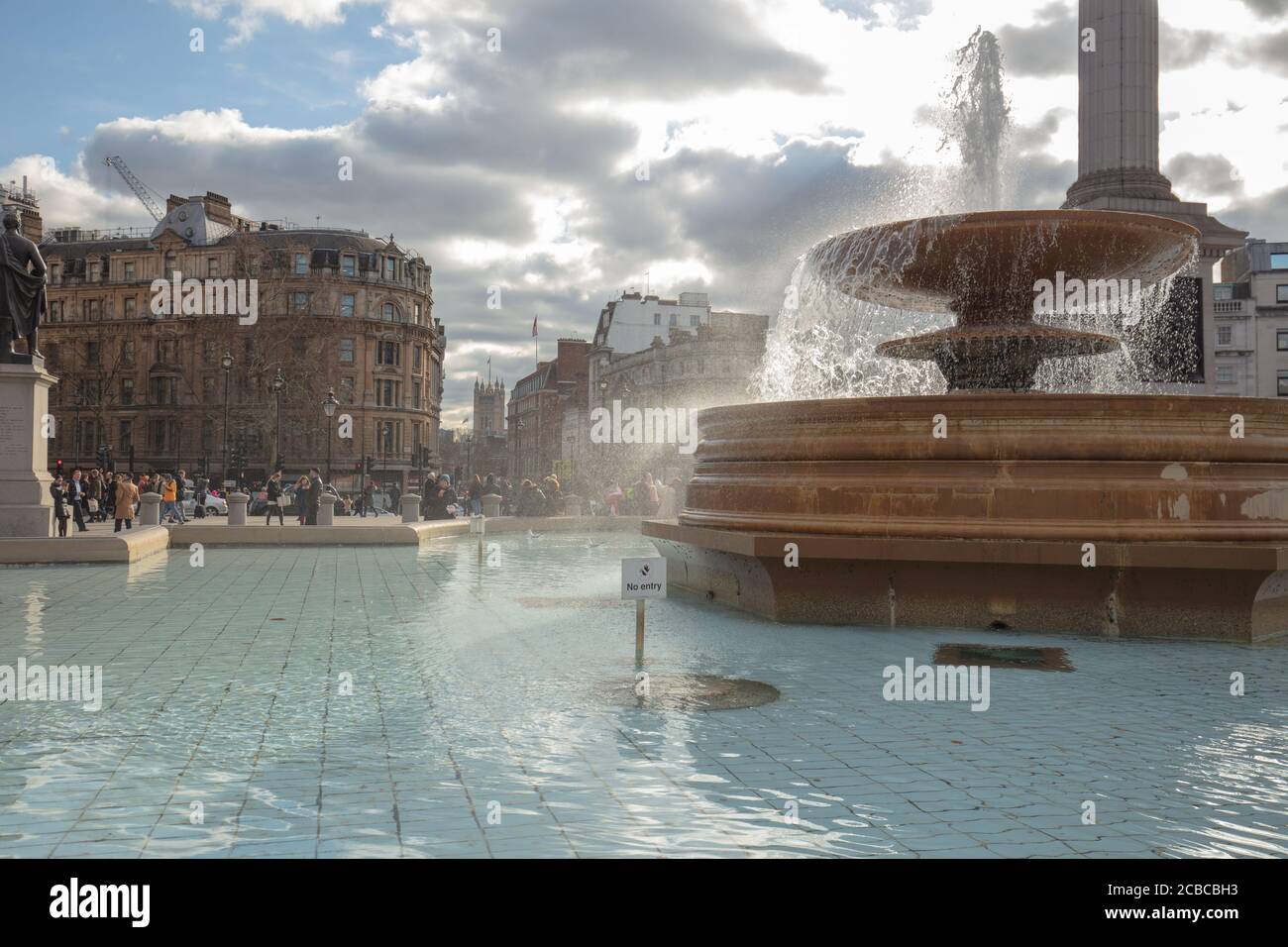 Vista general de una de las dos fuentes en Trafalgar Square Londres con un fondo de edificios y la columna de Nelson. Foto de stock