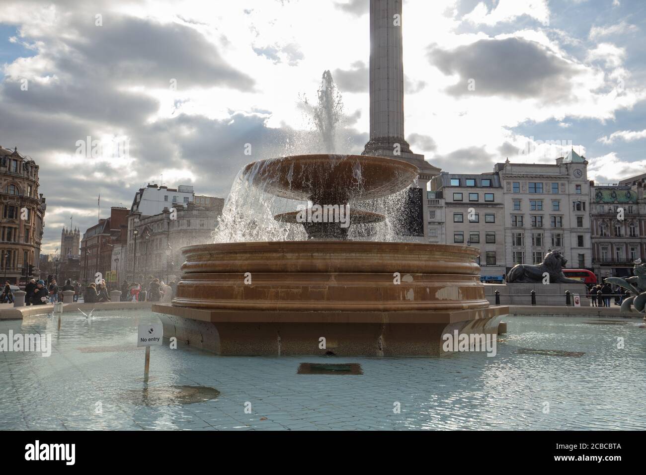 Vista general de una de las dos fuentes en Trafalgar Square Londres con un fondo de edificios y la columna de Nelson. Foto de stock