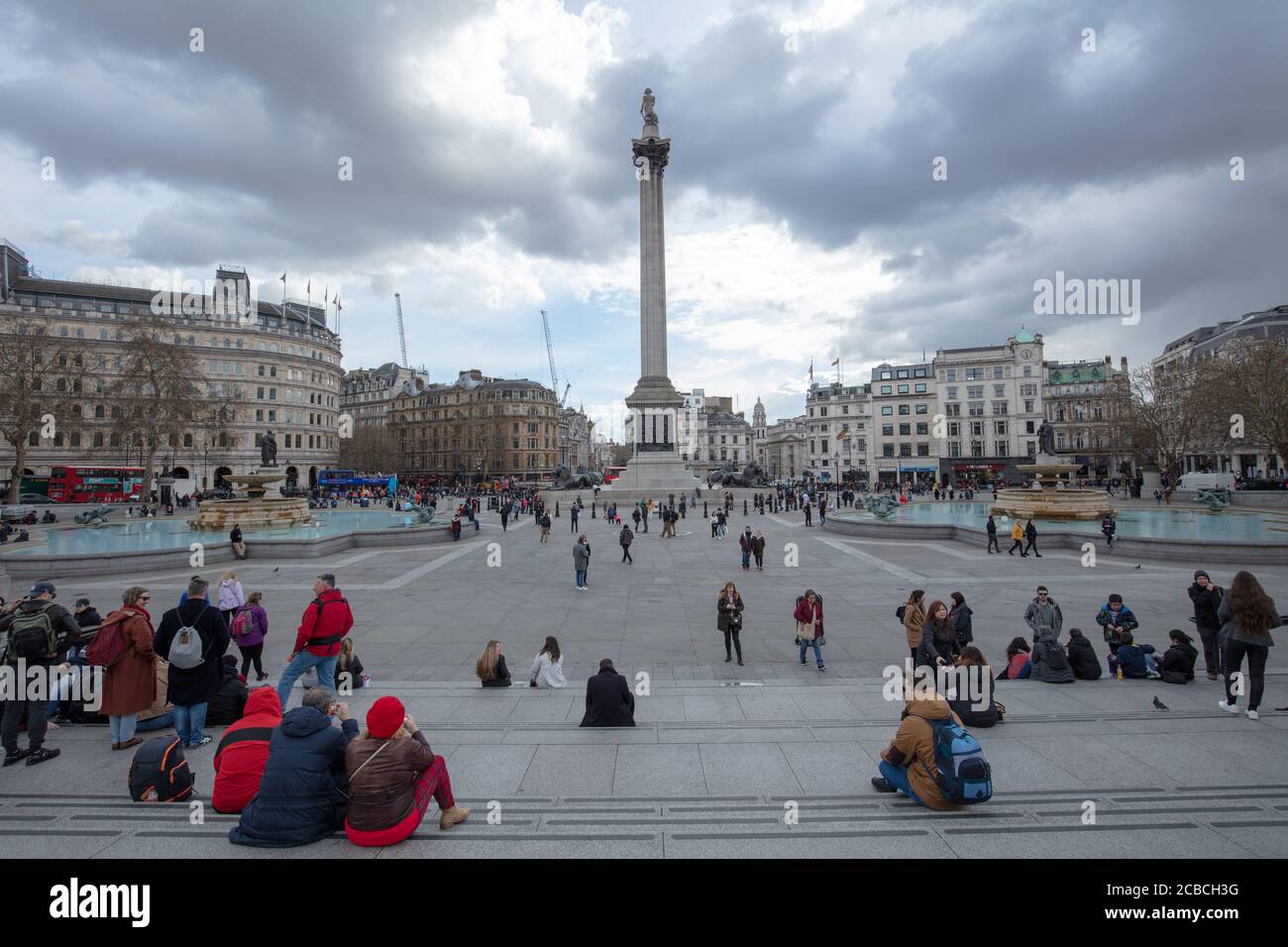 Turistas vistos en una vista general de la Plaza Trafalgar en un día nublado pero seco en marzo. Foto de stock