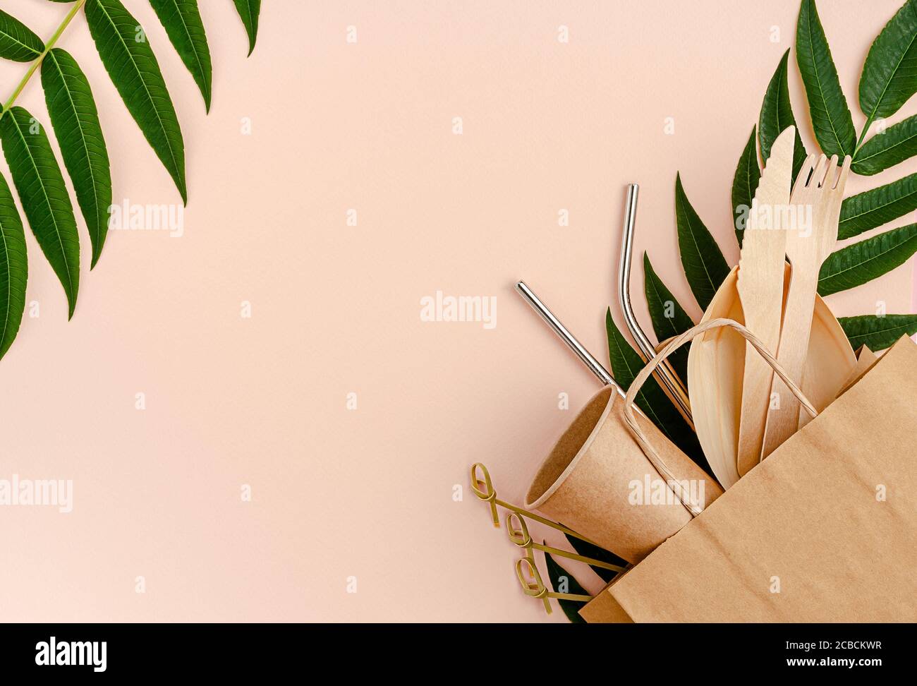 Juego libre de plástico con bambú, cubiertos de papel y pajitas de metal sobre fondo rosa. Concepto de cero residuos. Foto de stock