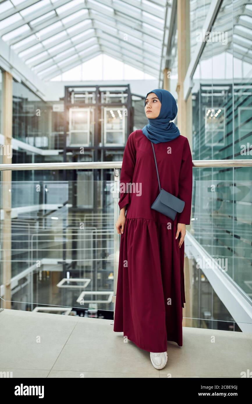 Joven hermosa mujer lleva ropa árabe tradicional de moda que consiste en vestido largo rosa y hijab Religión y Moda Fotografía de stock - Alamy