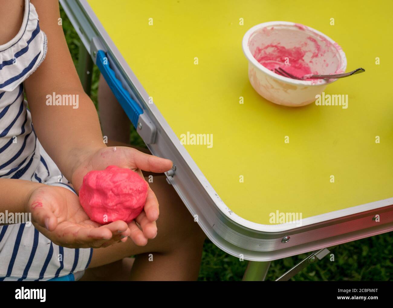 Sucediendo He aprendido Cha las manos de los niños con slime autohecho, hacer slime en una fiesta de  cumpleaños, el primer plano de un niño pequeño es la mano jugando un slime,  hecho a mano Fotografía