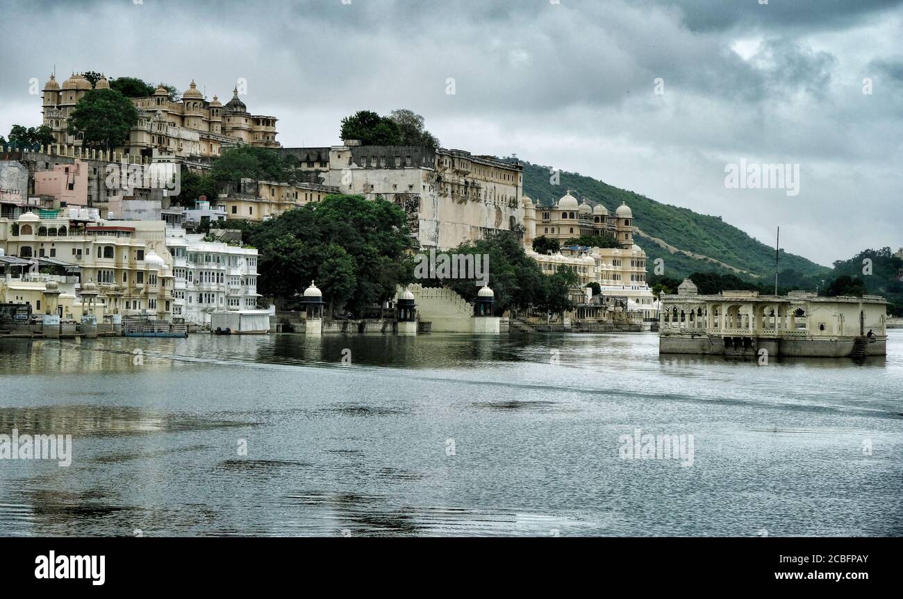 Vistas del Lago Pichola con el Palacio de la Ciudad de Udaipur en el fondo. Rajastan, India. Foto de stock