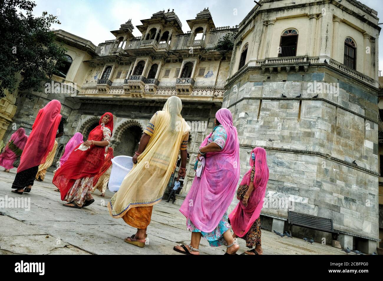 Udaipur, India - Agosto 2020: Mujeres caminando frente al Bagore-ki-Haveli cerca del Lago Pichola el 13 de agosto de 2020 en Udaipur, Rajastan. India. Foto de stock