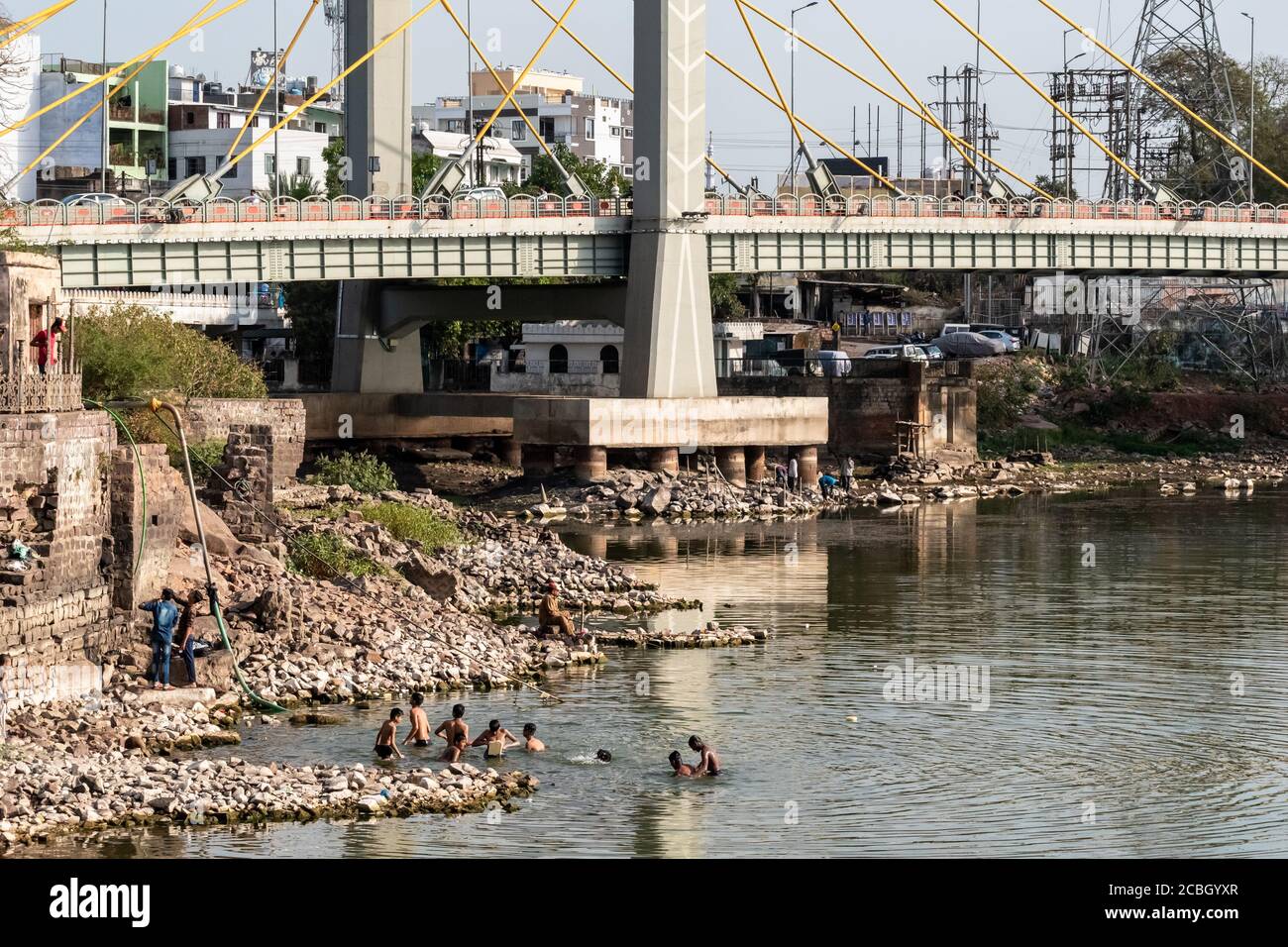 Bhopal, Madhya Pradesh, India - Marzo de 2019: Un grupo de chicos adolescentes indios bañándose en las aguas del Lago Superior en Bhopal debajo del puente Raja Bhoj Foto de stock