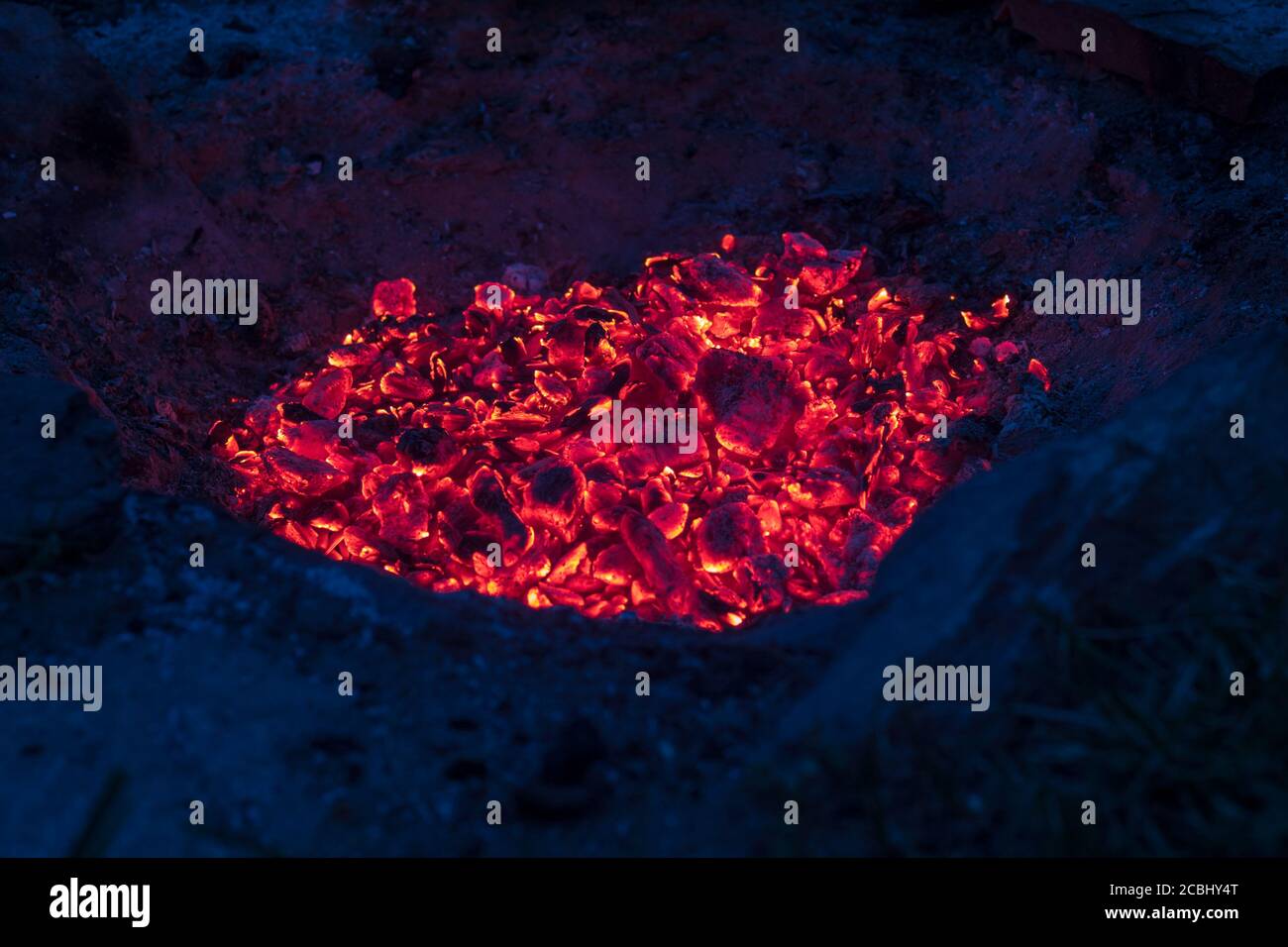 los carbones rojos en el fuego del campamento - brillando en el noche Foto de stock